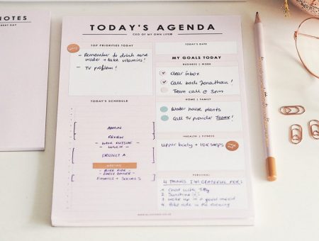 pastel pink 'todays agenda' notepad pile, completed with stationery surrounding it.