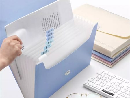 pictured is a powder blue multifunctional folder with numerous clear folder sleeves within.